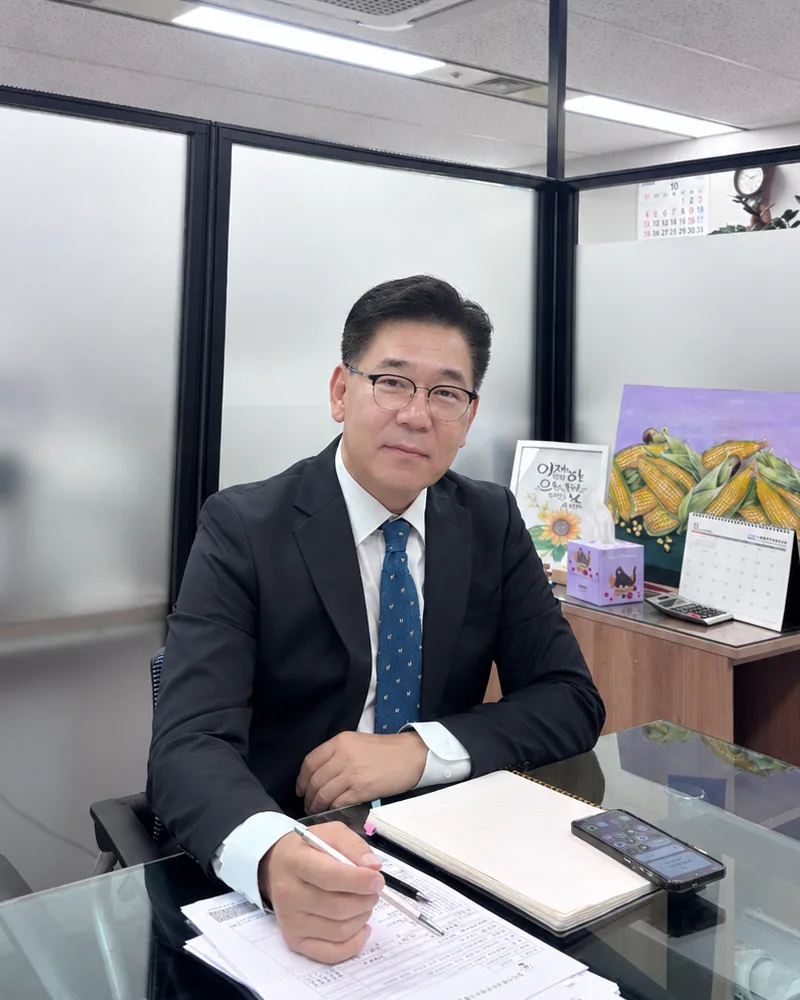 회의 테이블에서 서류에 메모하는 김희엽 법무사